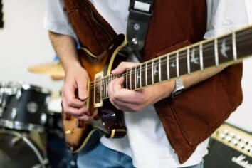 A close up of an electric guitar being played by an unknown person.