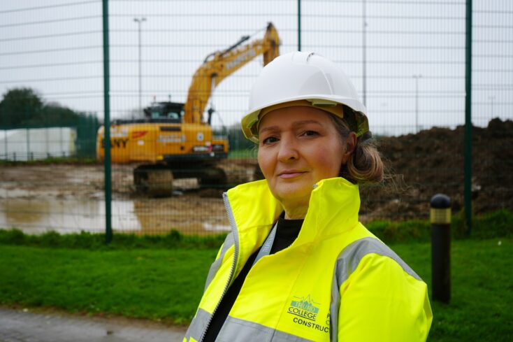 A image of Jay Wagstaff, project coordinator at Truro and Penwith College, wearing a hard hat and high visibility jacket with the Truro College logo.