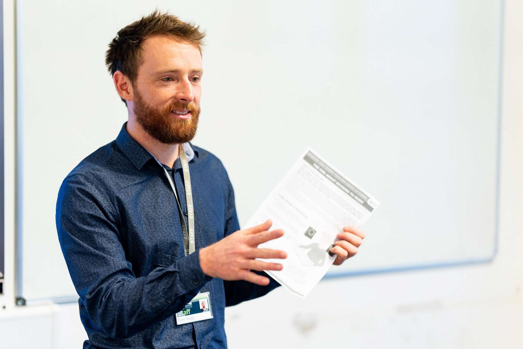 A close up of Tom Sugg. Department Team Leader for Nursing and Allied Health. Tom has papers in his hand.