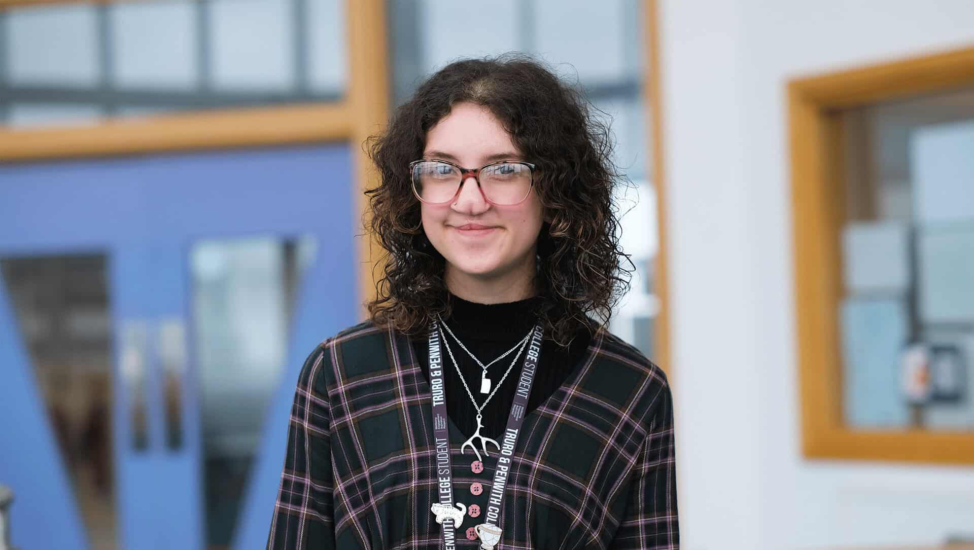 Student with glasses smiles at camera