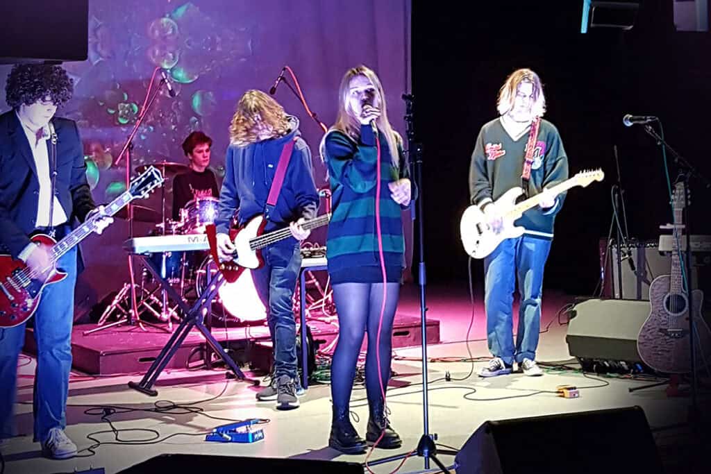 An image of five students playing in a band at the college.