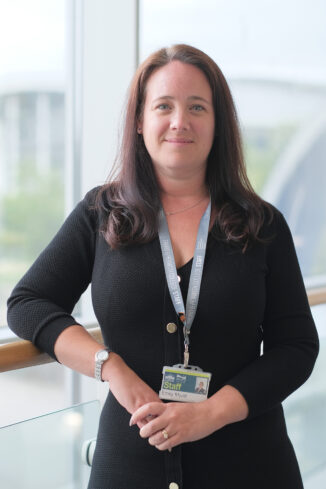 Emily Myatt Dean of the University Centre Truro & Penwith. Emily stands in front of a window in the Fal building.