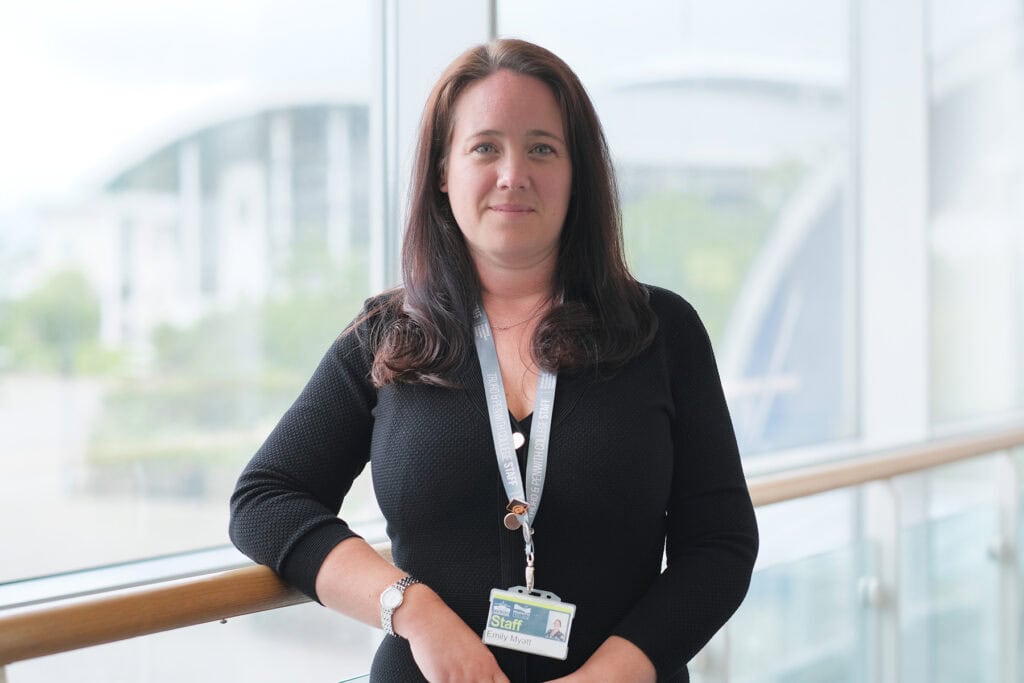 Emily Myatt Dean of the University Centre Truro & Penwith. Emily stands in front of a window in the Fal building.