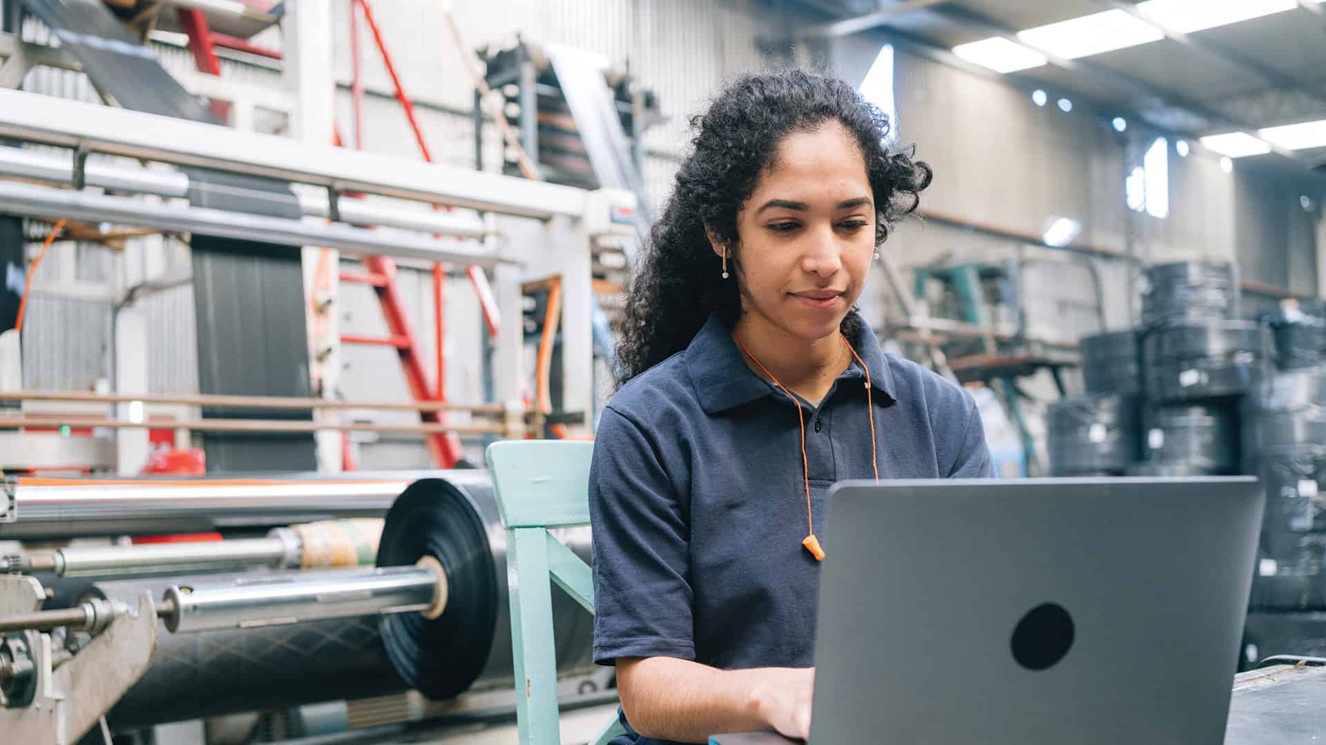 Engineer Working On Laptop In Plastic Recycling Factory