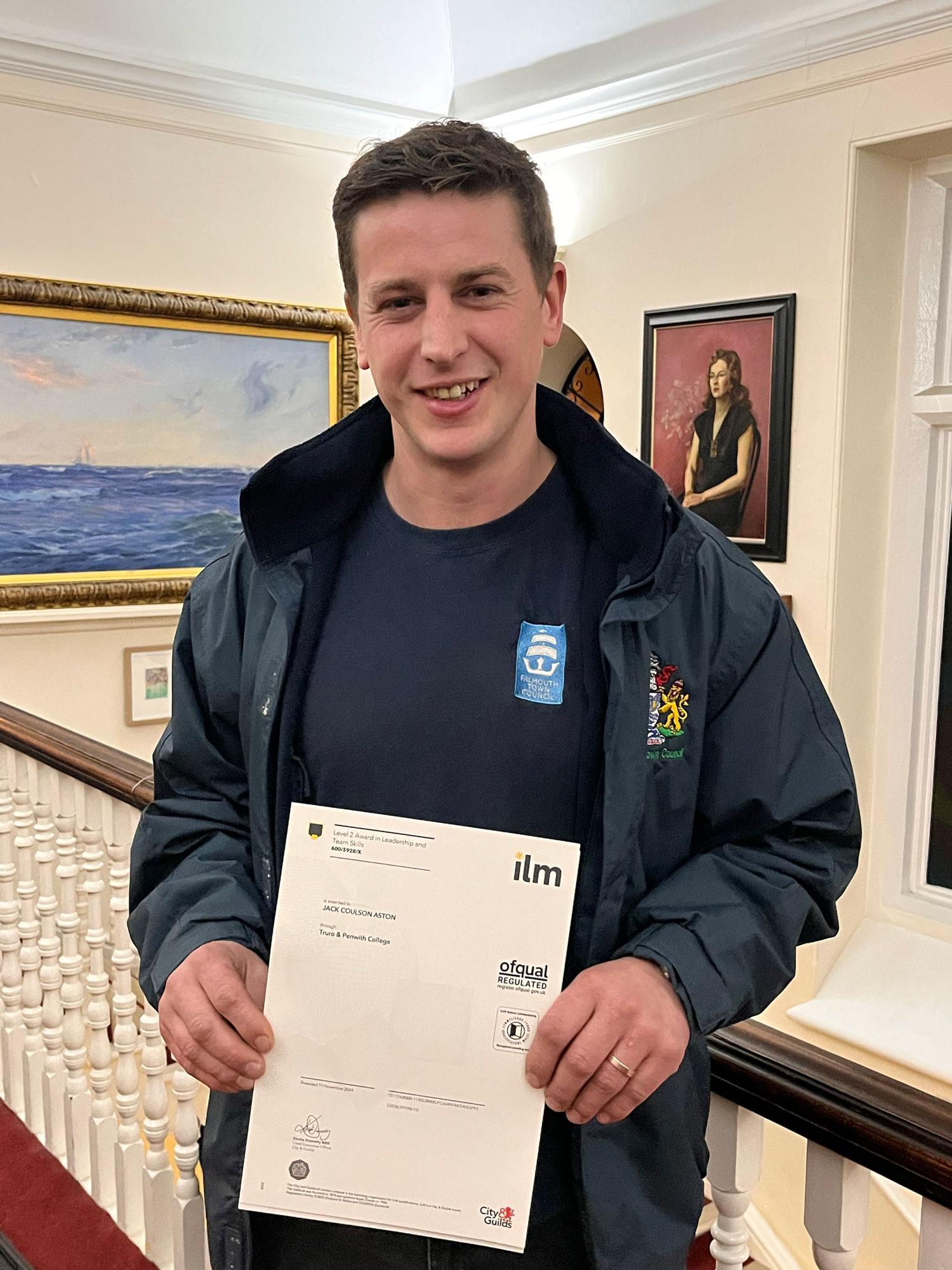 ILM student holding his Leadership and Management Certficate from Truro and Penwith College