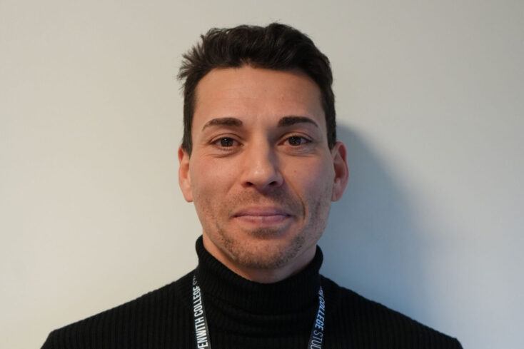 A protrait image of Jullius in a black jumper and wearing a lanyard.