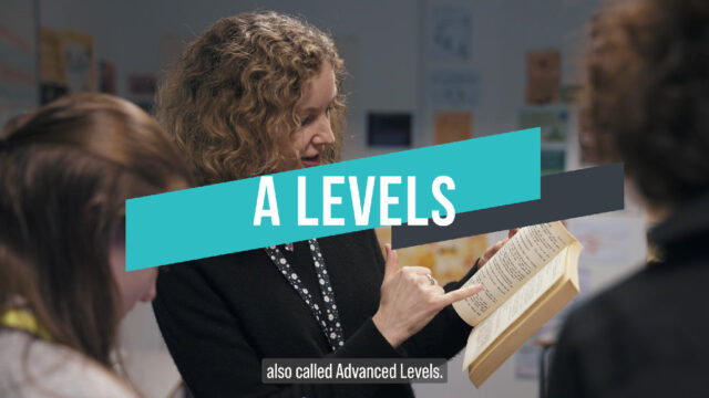 Thumbnail image for the A Levels video. The text in the centre of the screen says A Levels and subtitled at the bottom it says 'also called Advanced Levels'. The background image is of a tutor looking at a book with students.