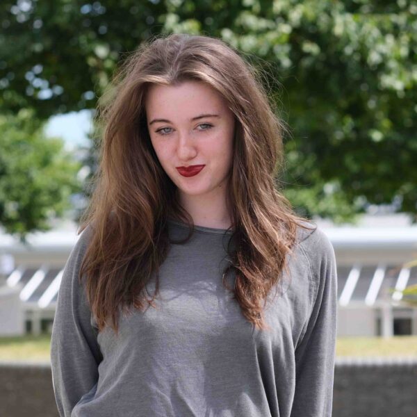 A photo of student, Brooke, who is wearing a grey t shirt and has red lipstick on.