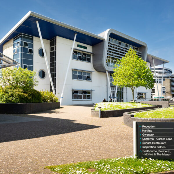A picture of the Sennen building at Penwith College on a sunny day. You can see the exterior of the building, a pathway and a directional sign.
