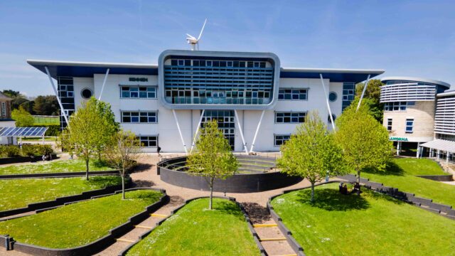 An image of the Sennen building at Penwith College on a sunny day. You can see the wind turbine behind the building and the blue sky.