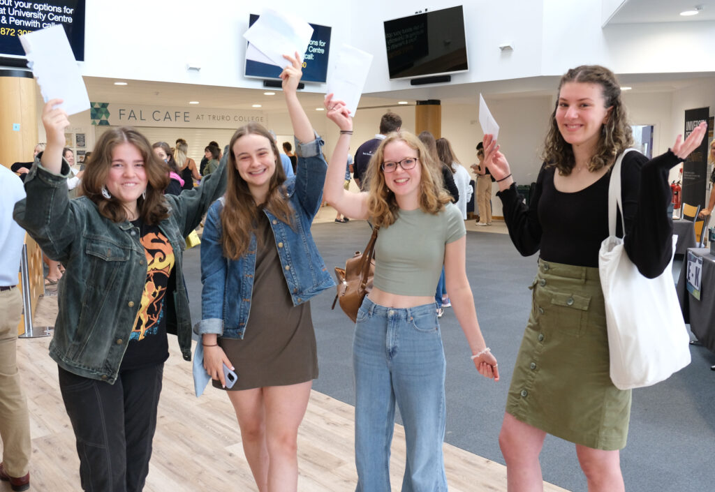 Students holding up their results in the Fal building.