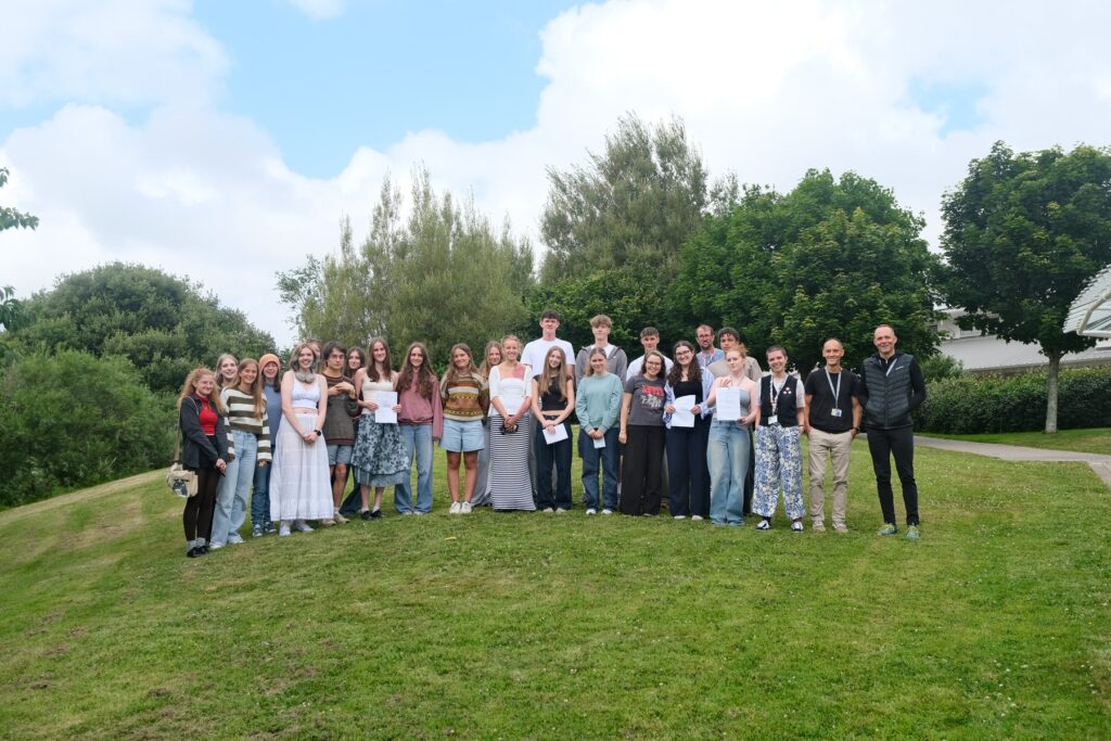 IB students gathere on the lawn after picking up their results - smiling down camera in celebration