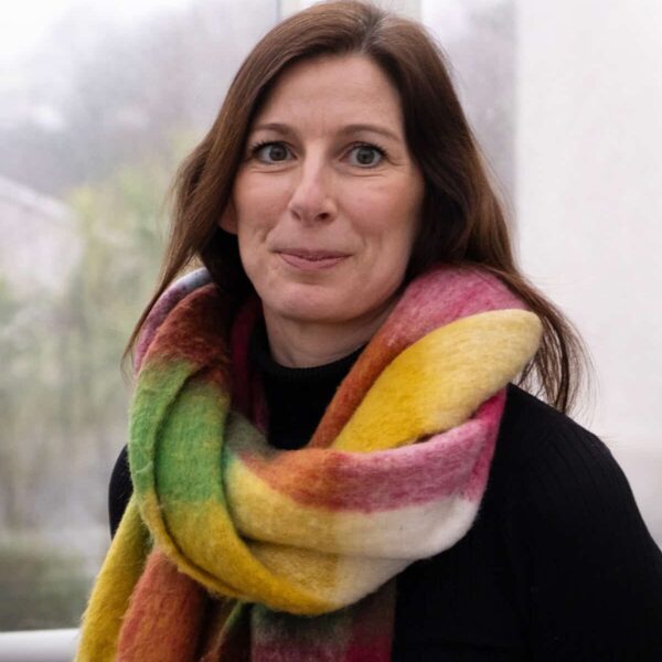 An image of Jodie Stafford, Department Team Leader for Personal and Professional Development at Truro and Penwith College. She is wearing a brightly coloured scarf against a dark top and smiling at the camera.