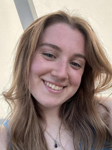 A portrait photo of Lauren Chessman. She has long hair and is smiling at the camera.