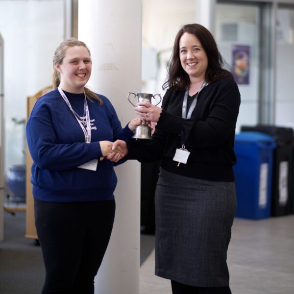 The Dean of the University Centre presents an award to a student.