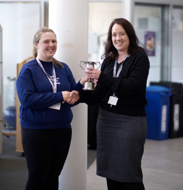 The Dean of the University Centre presents an award to a student.