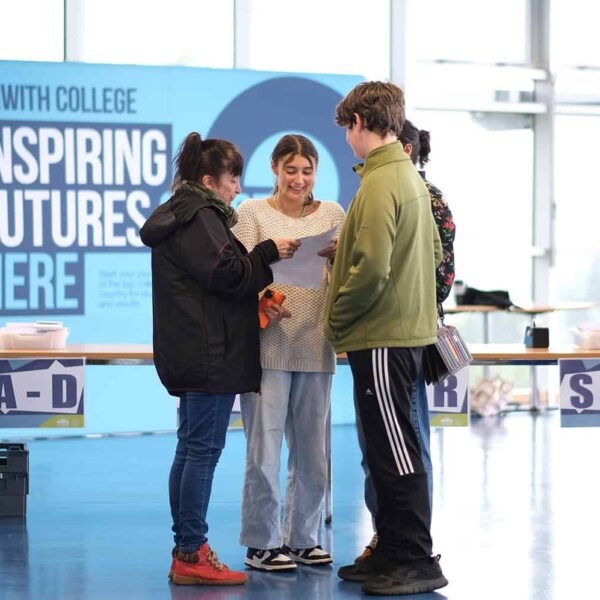 A student opens up their results with their family. They look happy.