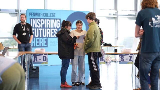 A student opens up their results with their family. They look happy.