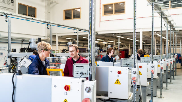 An image of the valency building at Truro and Penwith College. Students are using the engineering equipment with a member of staff present.