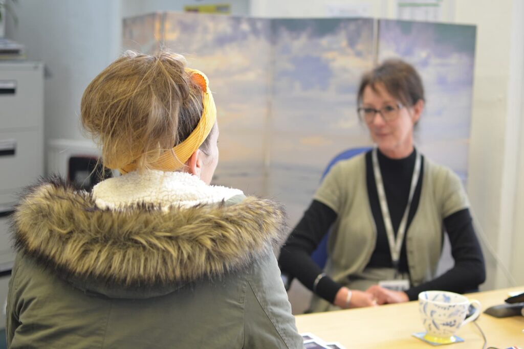 A student sits opposite a member of staff receiving support.