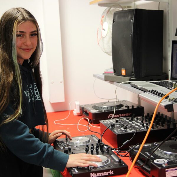 A student using music technology equipment in a studio.
