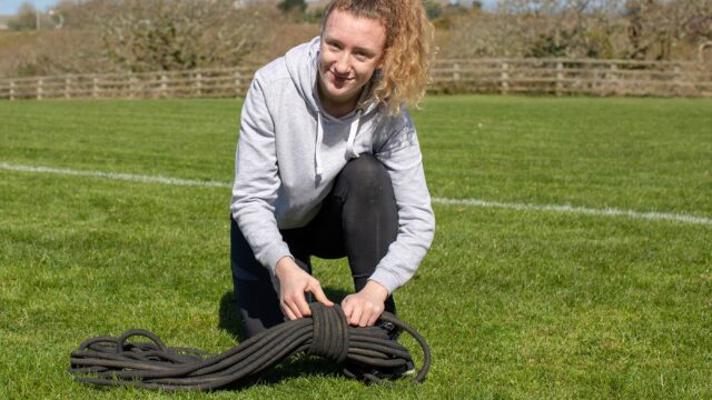 A student crouched in a sports field.