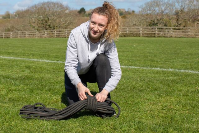 A student crouched in a sports field.