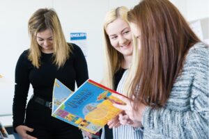 Students look through a children's book together.