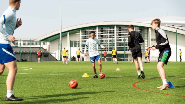Students play football on the astro-turf.