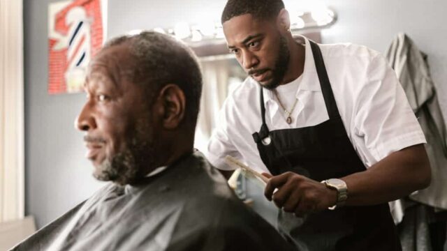 A barber cuts the hair of a client.