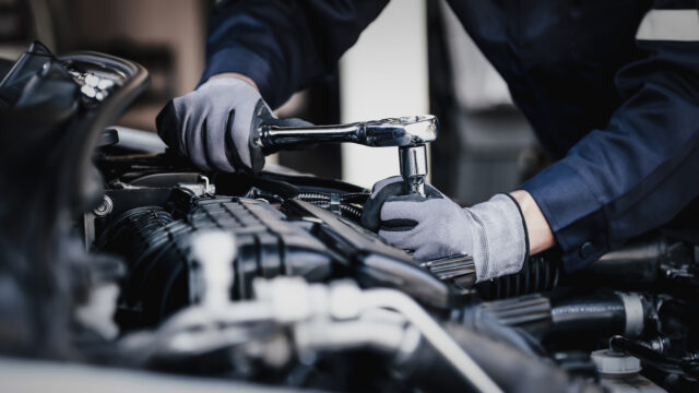 Professional mechanic working on the engine of the car in the garage.