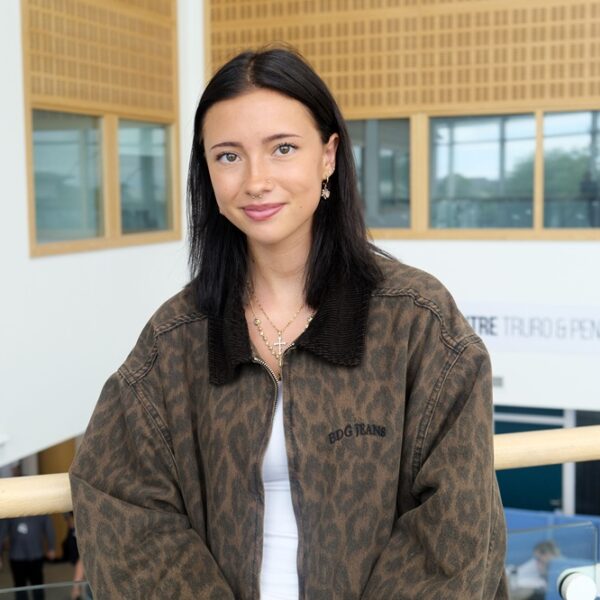 Becky is wearing an animal print jacket and smiles.