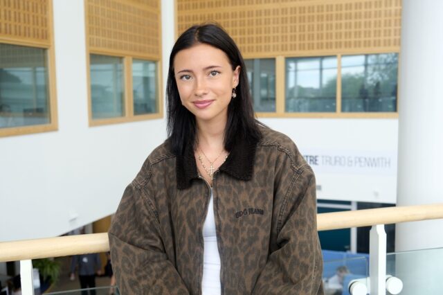 Becky is wearing an animal print jacket and smiles.