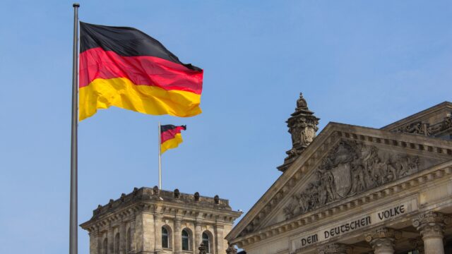 A German flag flying above a building.