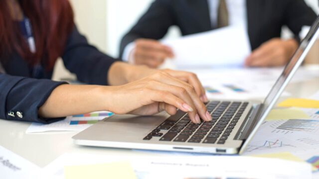 Close up hand of business woman using laptop.
