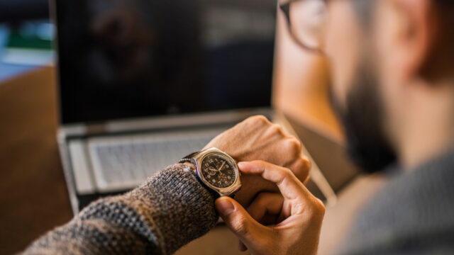 Young freelancer checking time while working.