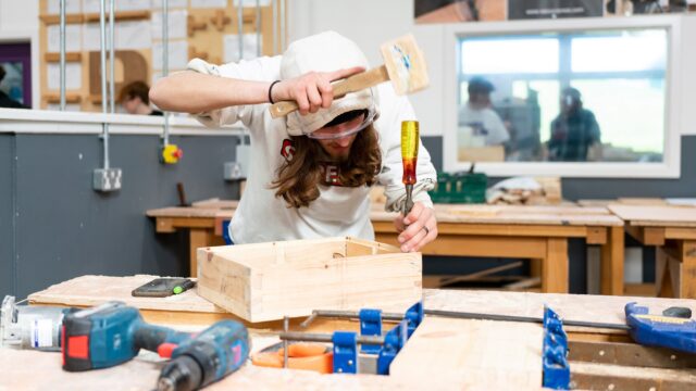 A student using tools in a workshop.