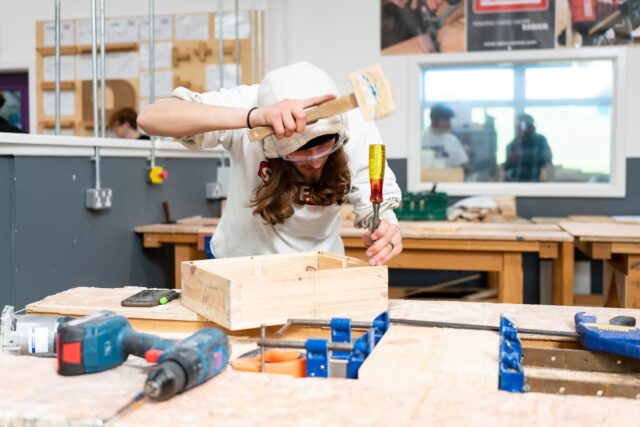 A student using tools in a workshop.