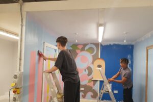 Two students painting walls.
