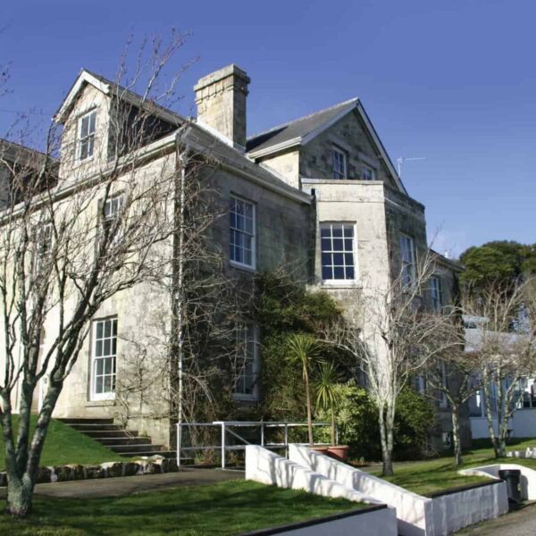 A picture of the exterior of Tregye house. The trees are bare signifying winter and the sky is blue.