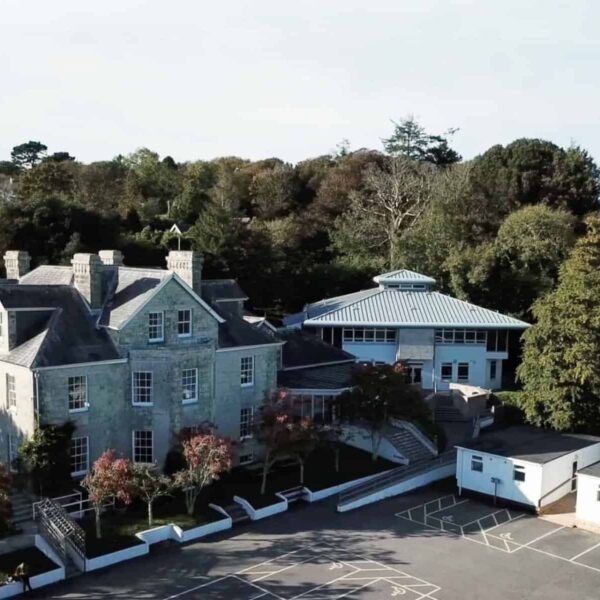 An aerial shot of the Tregye campus. You can see the car park and the main two buildings. There are lots of trees behind the buildings.