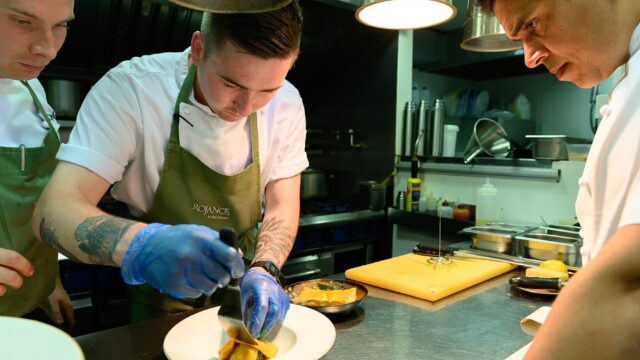 A chef from Rojano's plating a pasta dish.