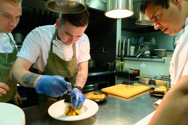 A chef from Rojano's plating a pasta dish.