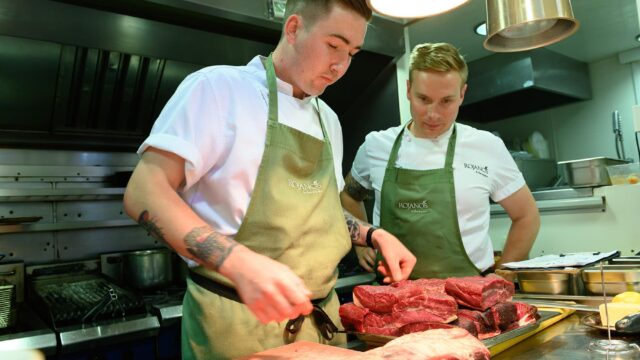 Chefs at Rojano's with plates of raw meat.