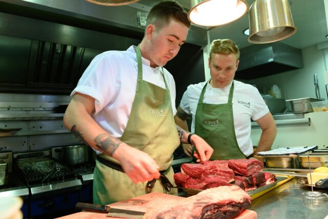 Chefs at Rojano's with plates of raw meat.