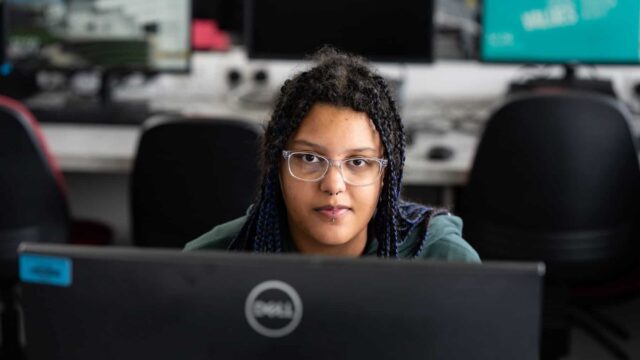 A student looks over the top of the computer.