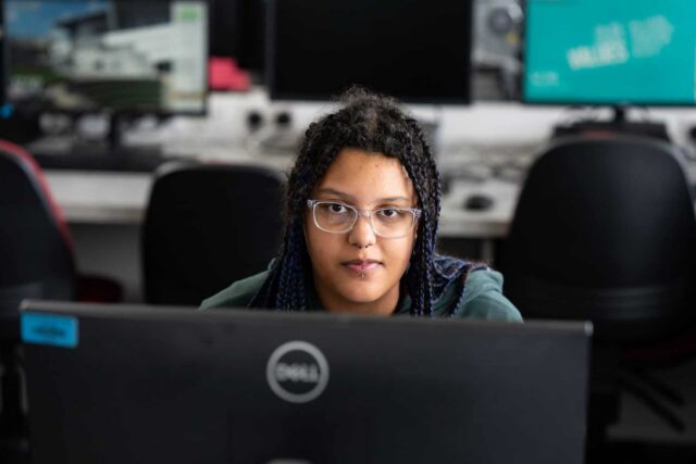 A student looks over the top of the computer.