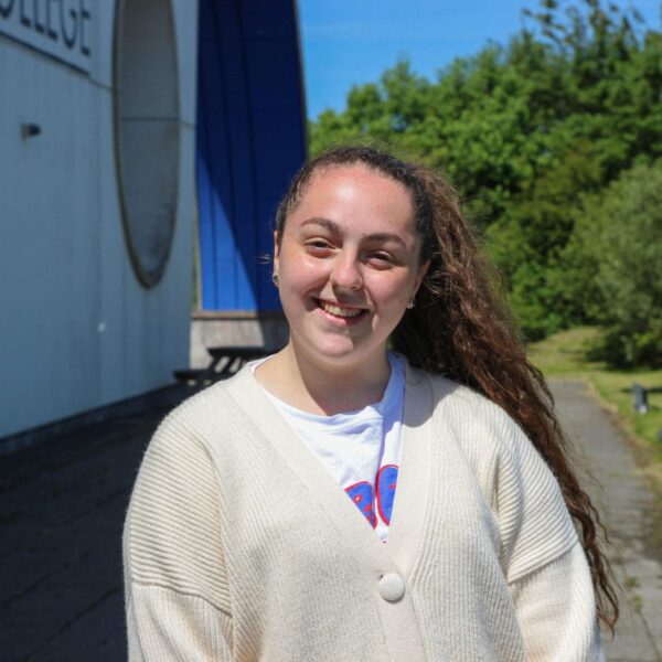 Daisy stood outside the college in the sun.