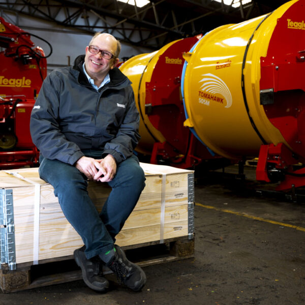 Duncan Wilson sitting on a pallet in the Teagle workshop.