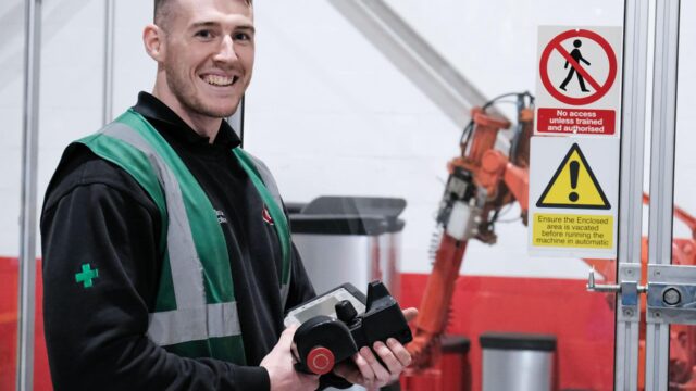 An engineer wearing high vis jacket smiling.